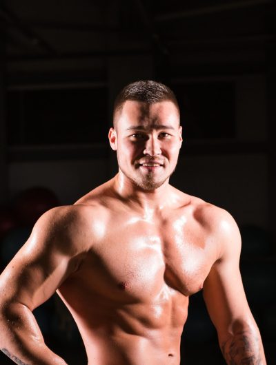 Handsome muscular bodybuilder posing over black background.