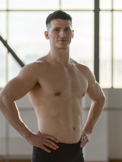 Smiling hispanic athlete standing indoors looking at camera. Healthy lifestyle concept